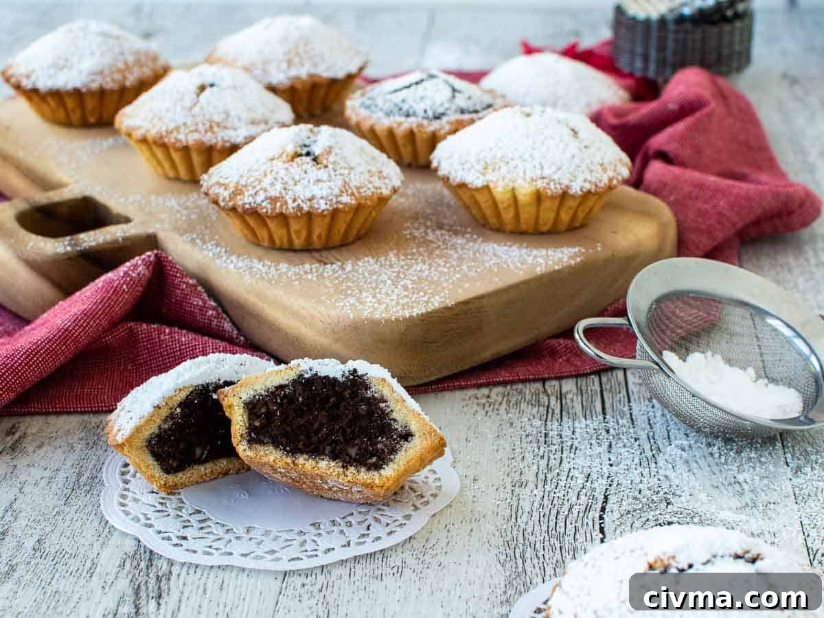 Bocconotti: Italian Chocolate-Almond Pastries from Puglia 13 Small chocolate pies on a wooden board with one cut in half at the front.