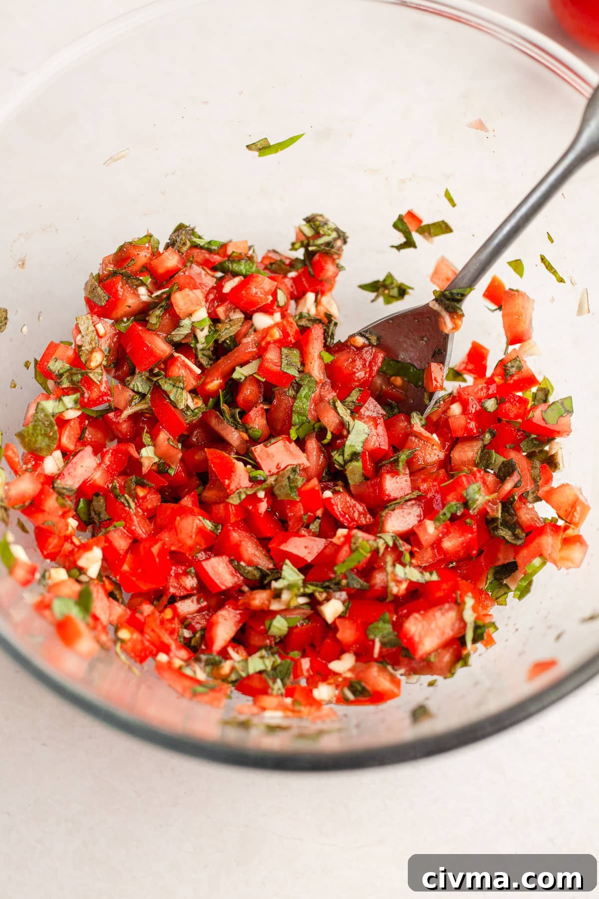 Ingredients for quick homemade bruschetta including tomatoes, herbs, garlic, olive oil, and bread