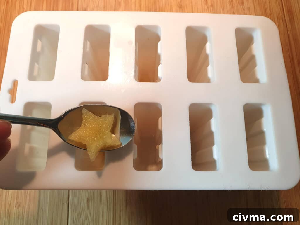 Adding apple stars to popsicle moulds.