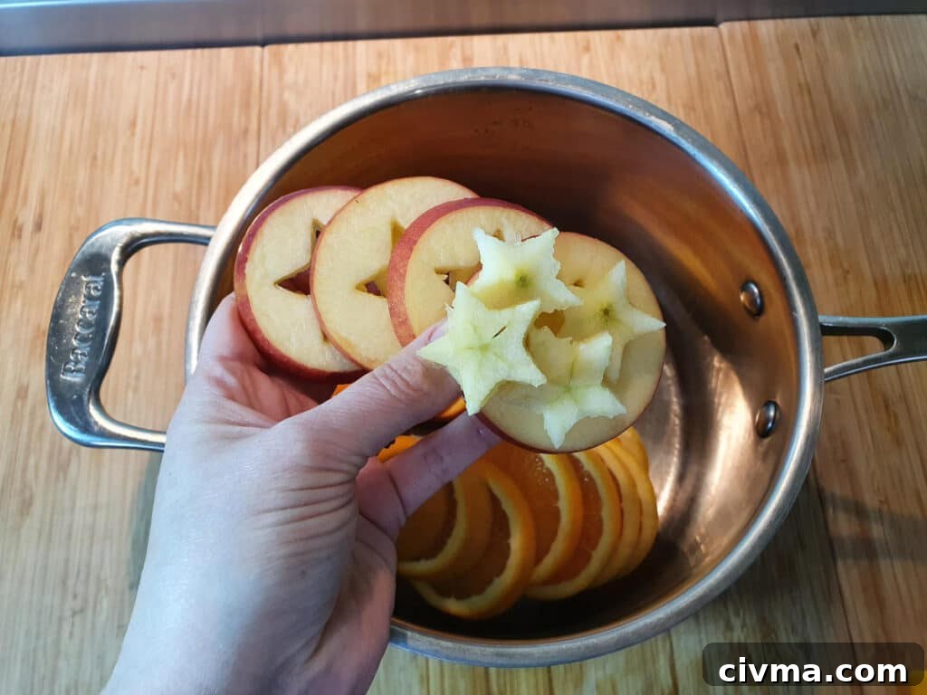 Adding apple slices and star shapes to pot.