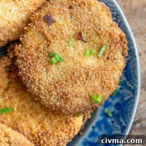 several fried green tomatoes on a blue platter, topped with chopped green onions
