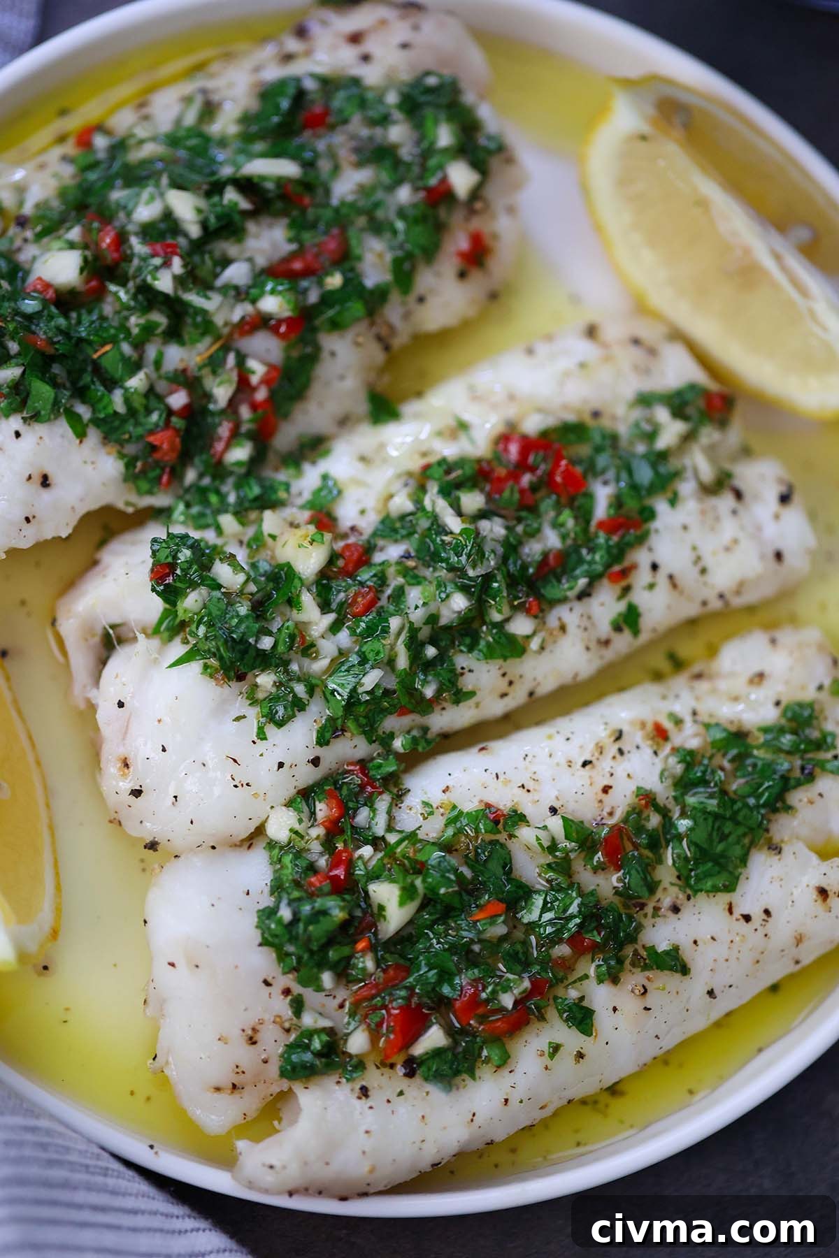 Baked Cod with Chimichurri Sauce 5 Baked cod with chimichurri on a white plate.