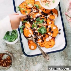 Sweet potato nachos on a tray with a child's hand reaching in.