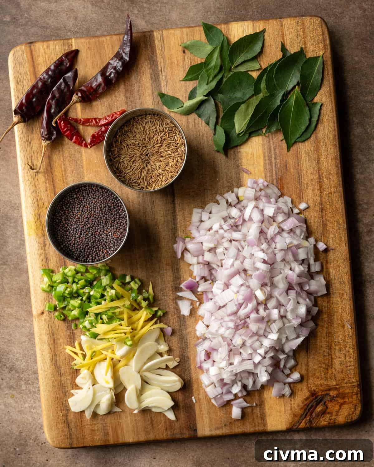 Tadka ingredients chopped and in small bowls on cutting board.