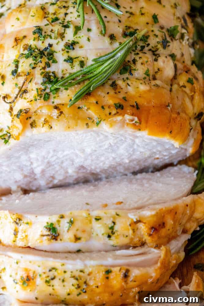 A close up of a roasted turkey breast with rosemary sprigs.