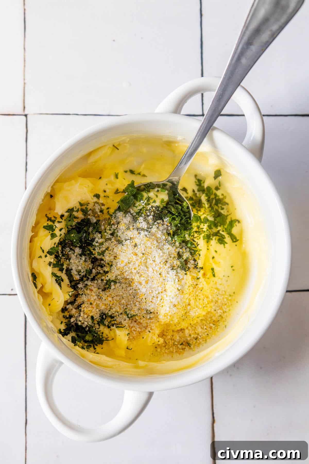 A white bowl filled with butter and herbs.
