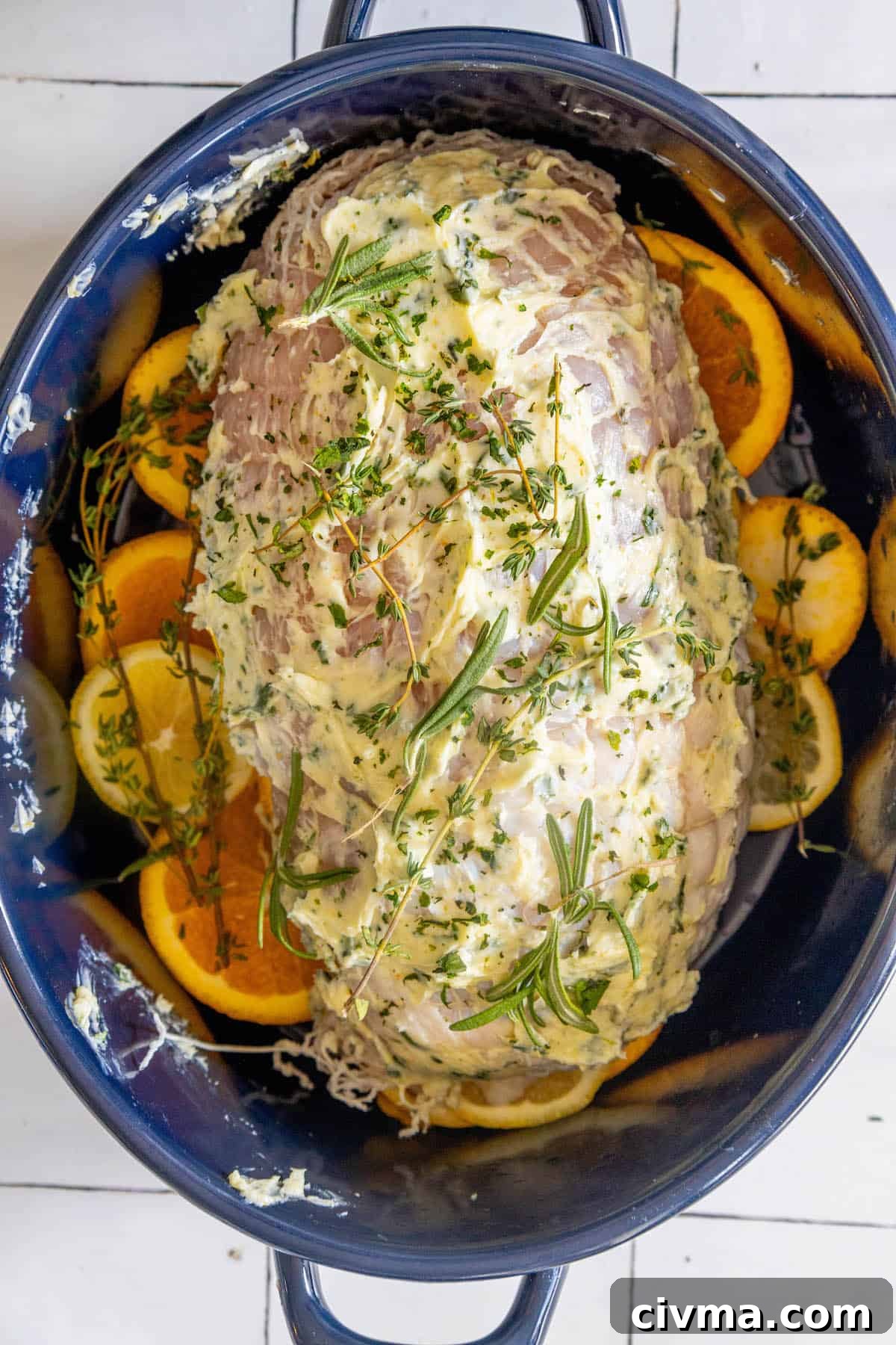 A pot filled with oven baked turkey breast and orange slices.