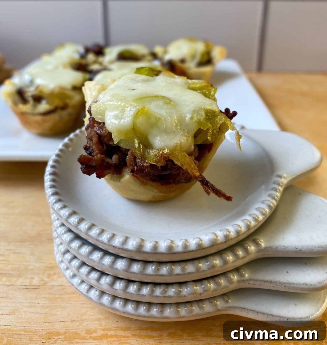 Philly Cheesesteak Bites Recipe 11 mini cheesesteak bite on a stack of tasting plates.