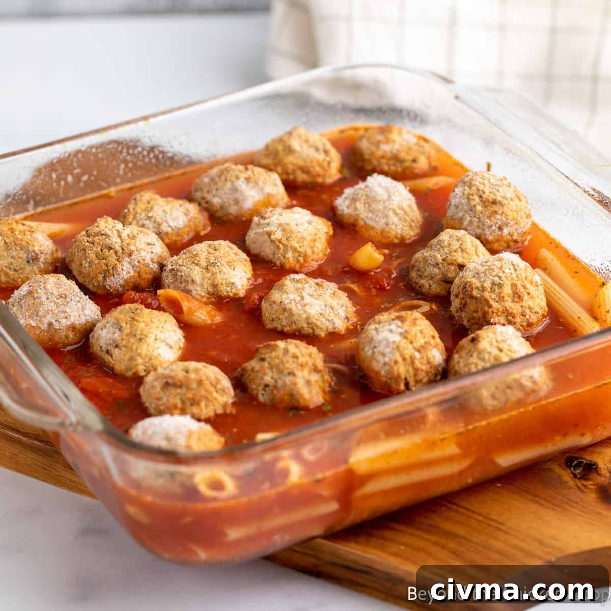 Frozen meatballs with sauce and pasta in a glass dish. 