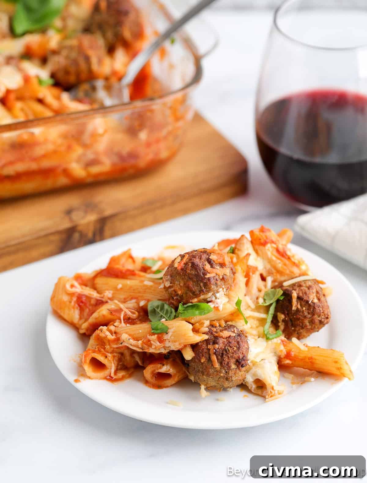 Pasta and meatballs on a white plate. 
