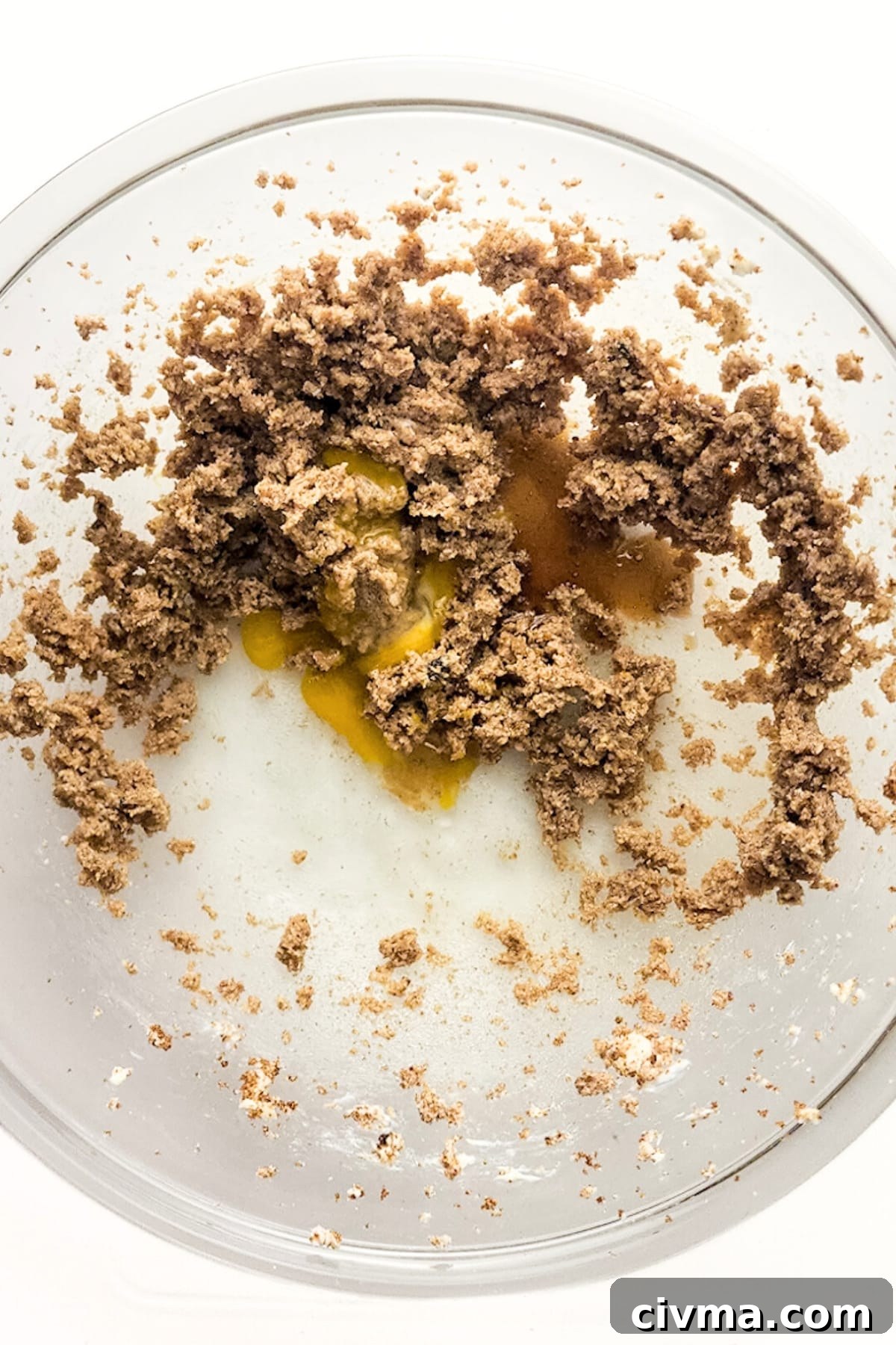 Mixing egg yolk, butter and sugar mixture in bowl.