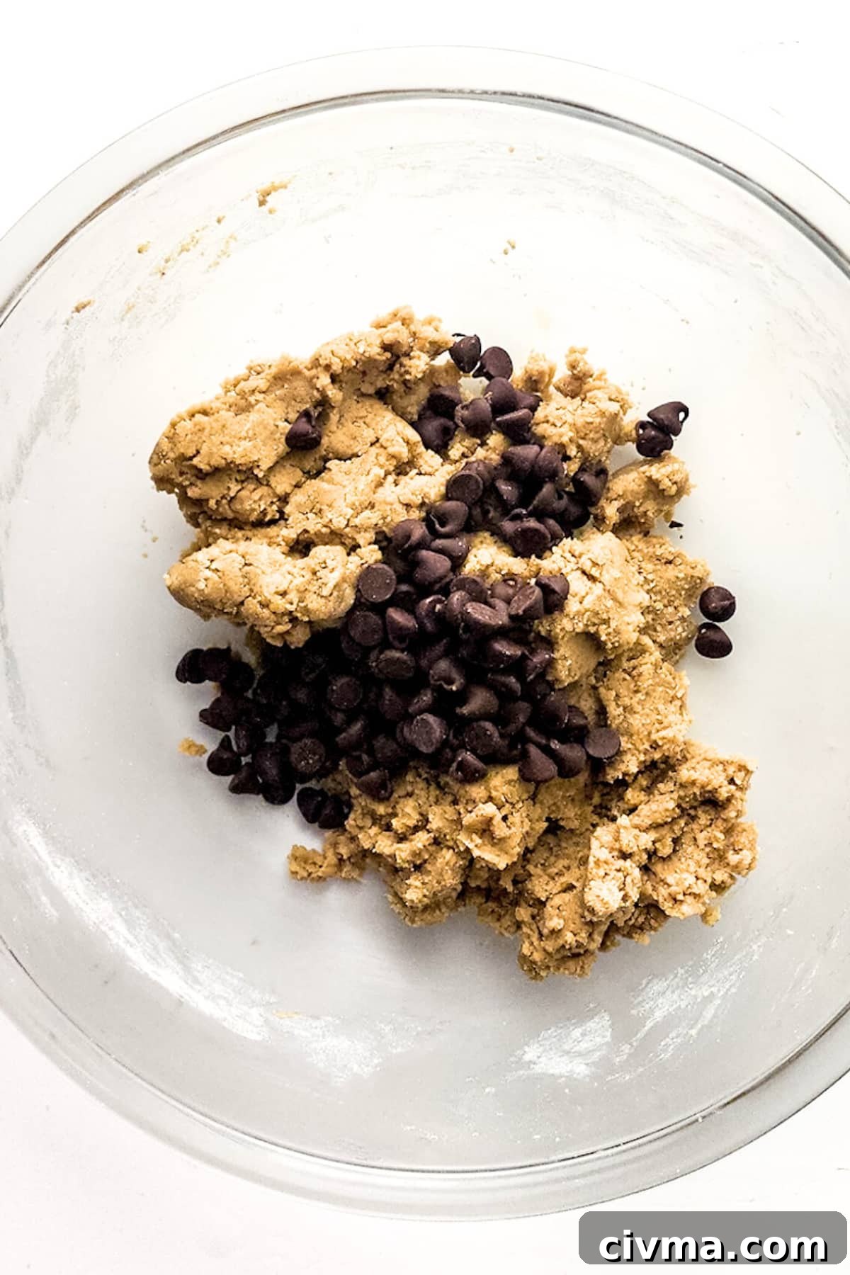 Mixing chocolate chips into cookie dough.