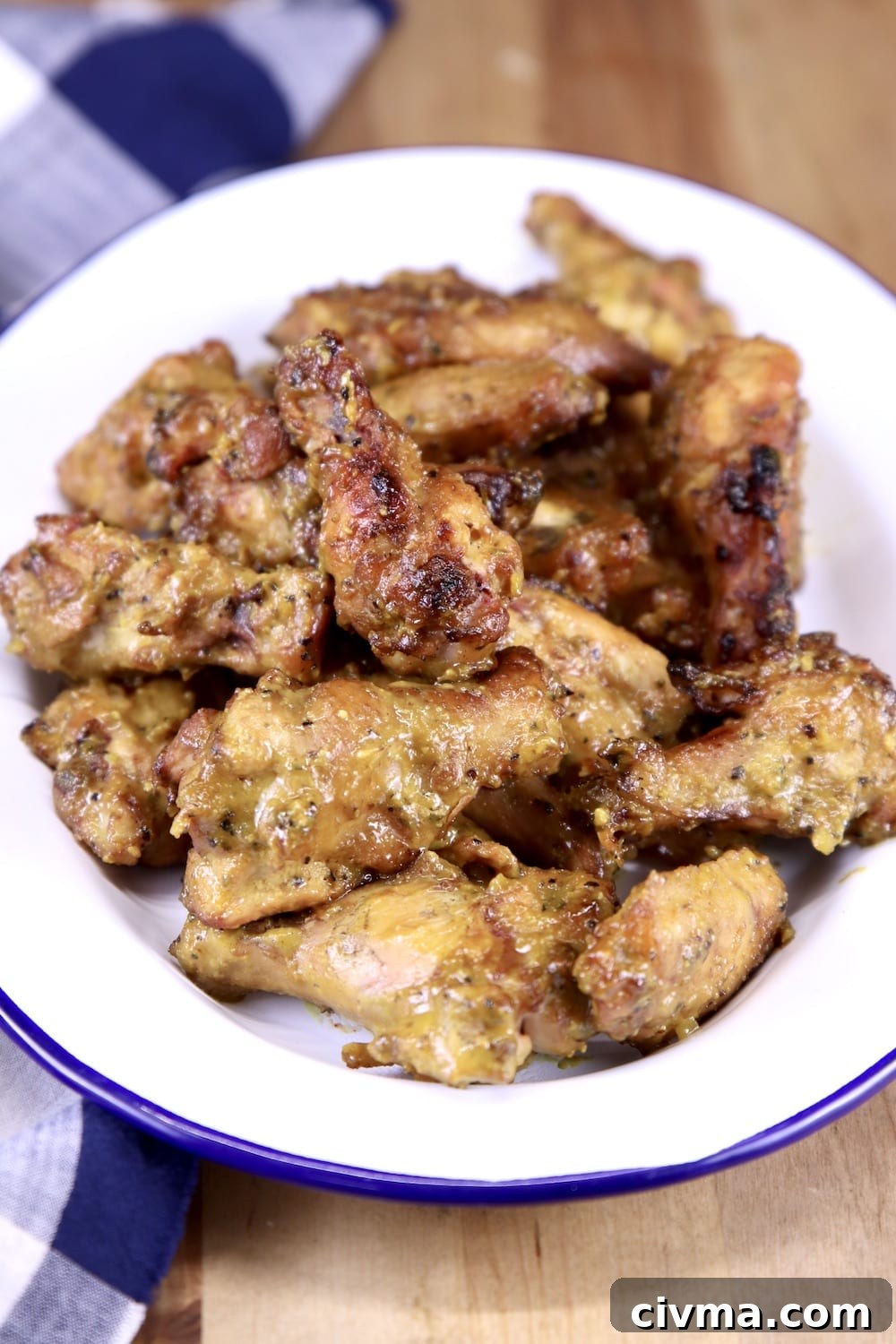 rosemary mustard chicken wings recipe grilled on a Big Green Egg Rosemary Mustard Chicken Wings on a white platter