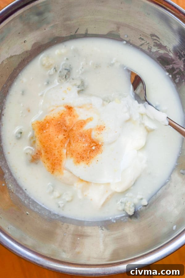 Buttermilk, yogurt, paprika and blue cheese in a metal bowl
