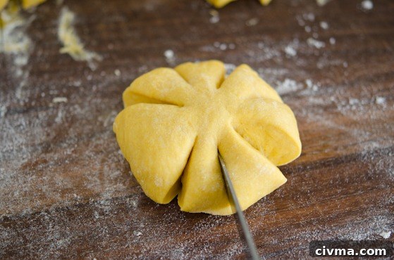 The flatten dough gets a few slits by a knife.