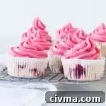 frosted raspberry cupcakes sitting on a wire rack