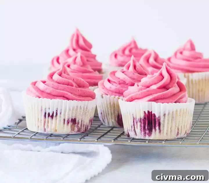 frosted raspberry cupcakes sitting on a wire rack