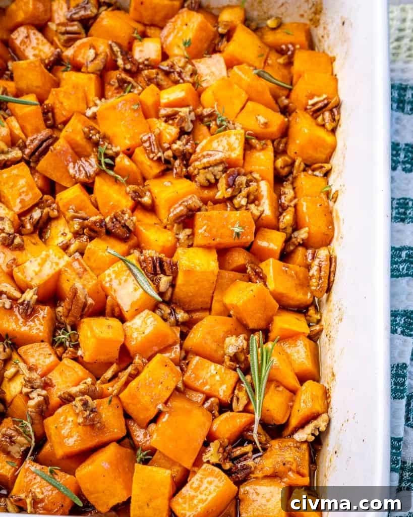 A white dish of roasted sweet potatoes on a cloth.