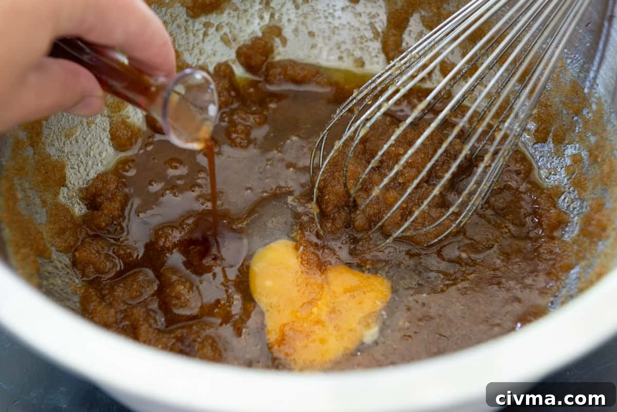 Adding the vanilla extract and egg to butter and sugar