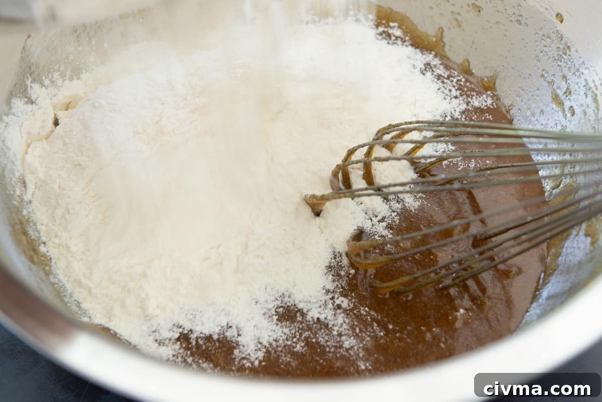 Adding the dry ingredients to the wet ingredients in mixing bowl
