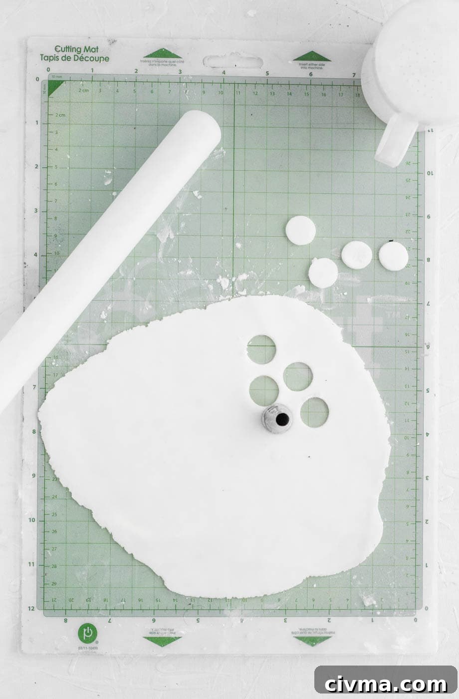 Cutting white fondant circles for poop emoji cupcake eyes