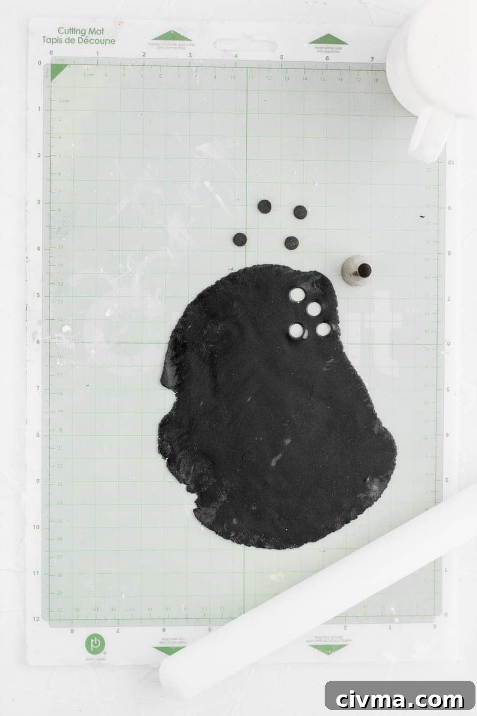 Cutting black fondant circles for poop emoji pupils