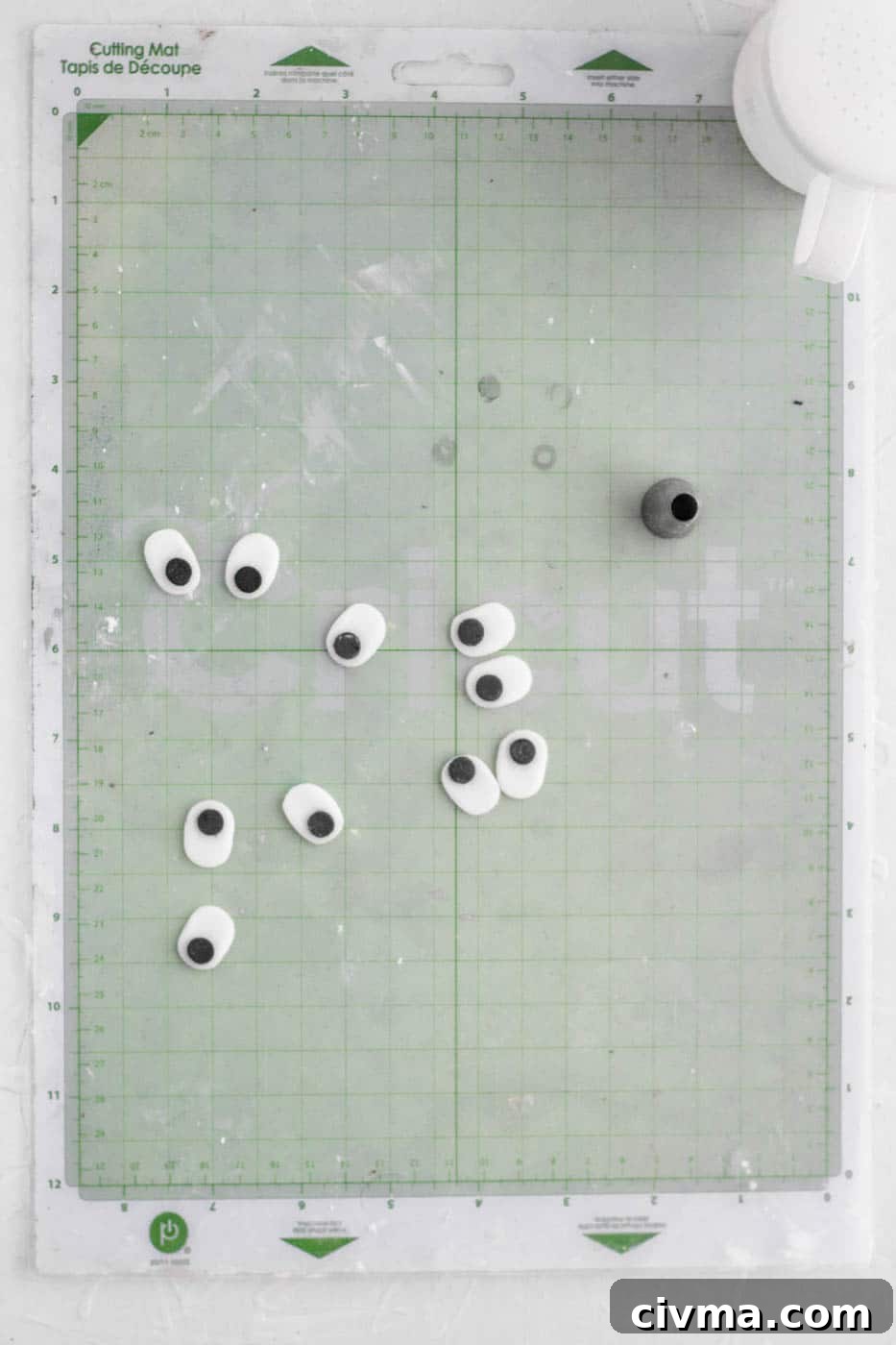 Attaching black fondant pupils to white fondant eyes