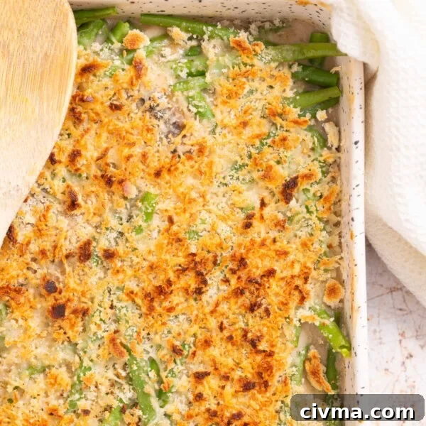 An overhead, close up image of green bean casserole with a golden layer of cheese on top.