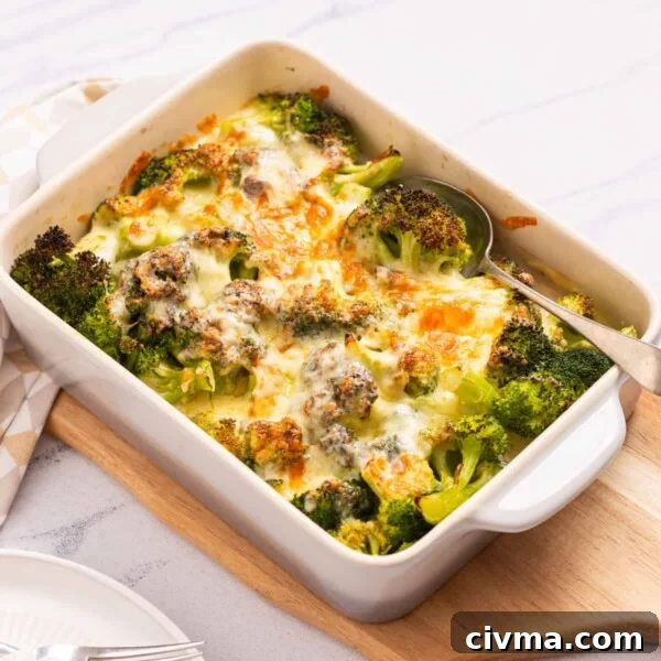An image of broccoli cheese casserole served on a table with a spoon on the right side.