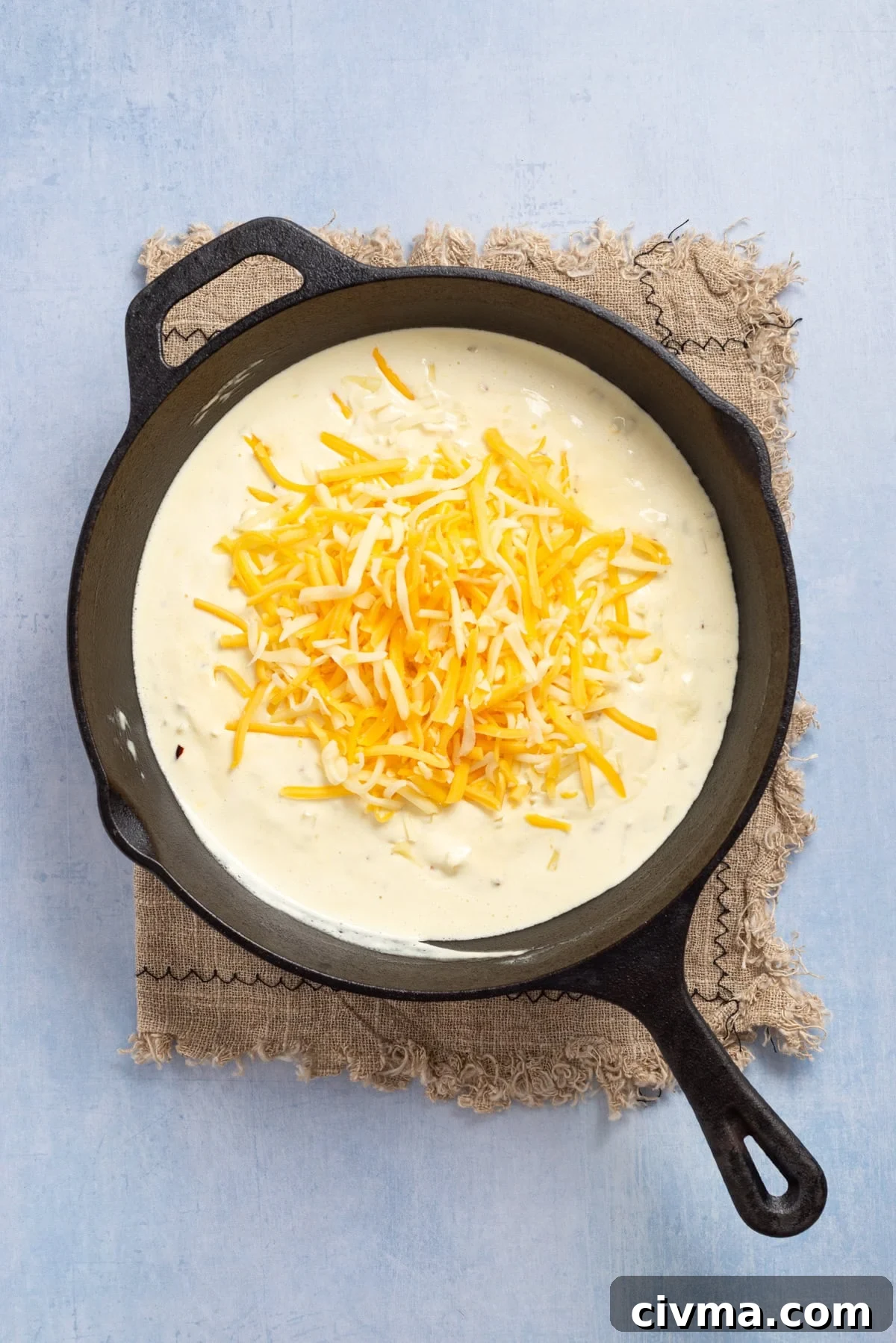 An overhead image of adding cheese to the mixture.