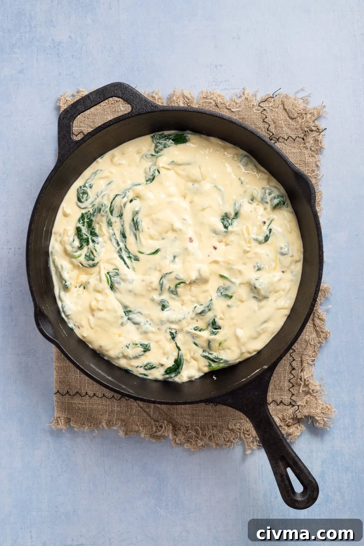 An image of adding the spinach to the mixture.