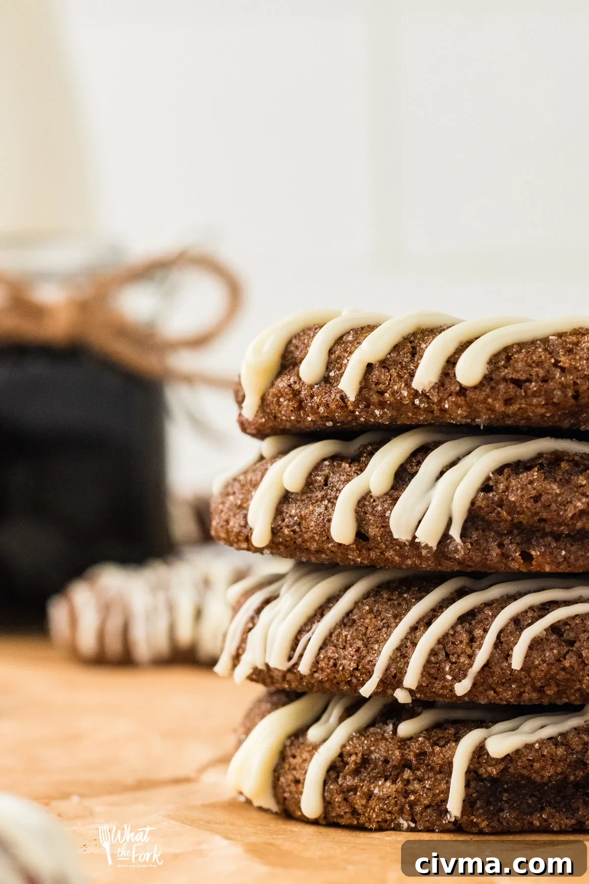 soft and chewy Gluten Free Ginger Cookies made with double molasses are drizzled in white chocolate and stacked in a group of 4