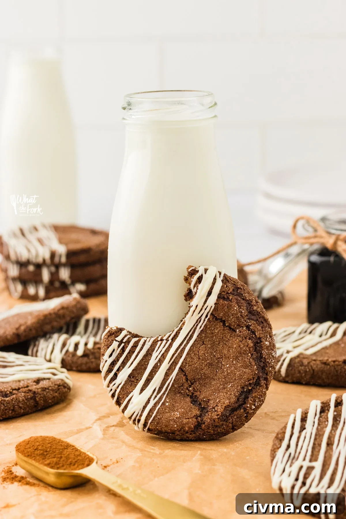 a gluten free ginger cookie with a bite taken out is leaning agains a small bottle of milk