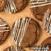 overhead shot of baked Double Molasses Gluten Free Ginger Cookies that have been drizzled with white chocolate on top of brown parchment paper