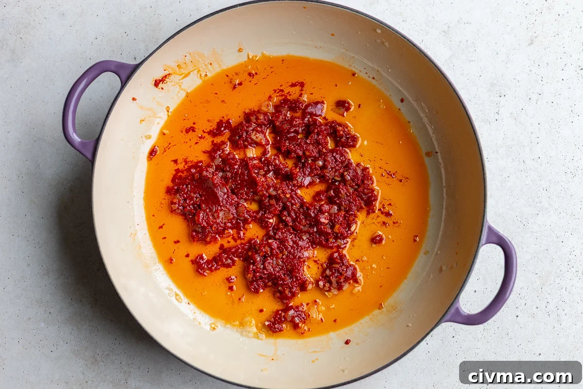 shallot garlic and tomato paste cooking in a skillet for vodka sauce butter beans
