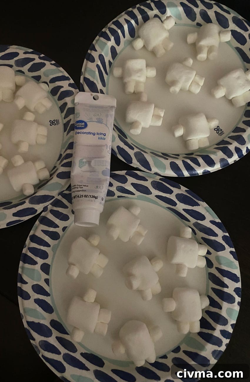 adipose marshmallows on paper plates with a tube of white decorating frosting