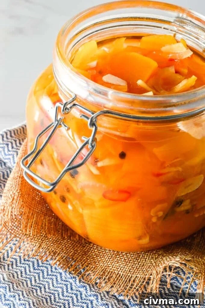 Front view of sliced pumpkin and garlic and red chilis in a glass jar