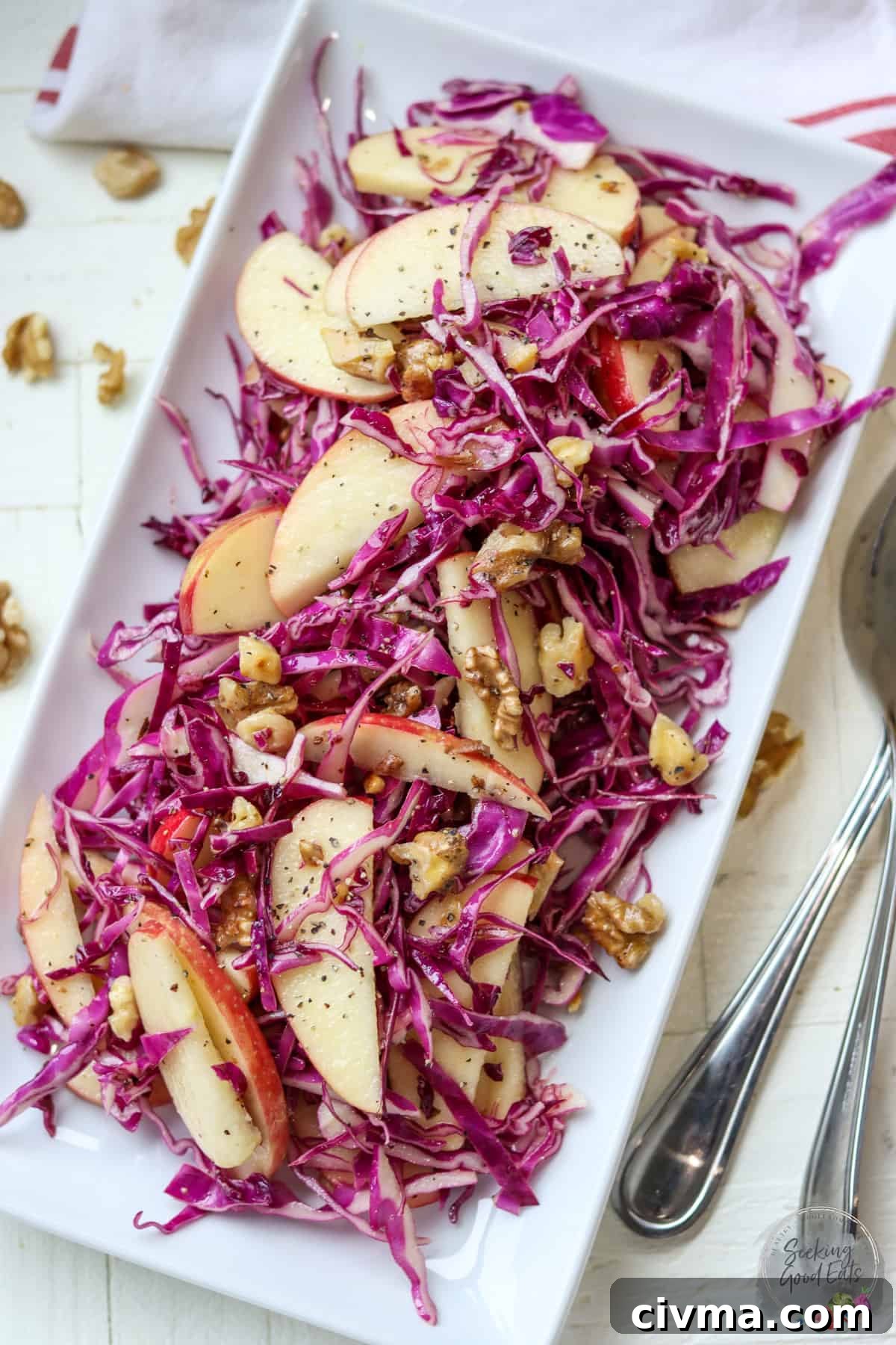Red cabbage salad with apples and walnuts on a white plate