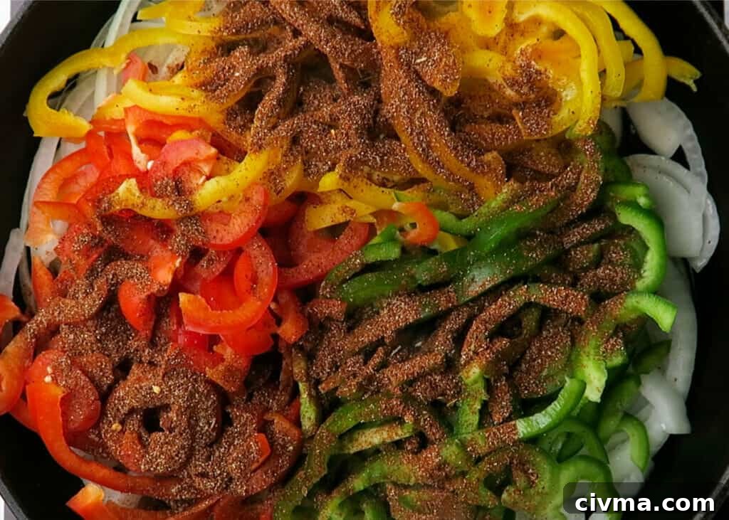 Bell peppers and onions cooking in a skillet for steak fajitas