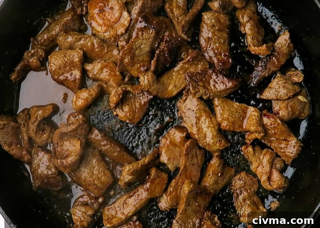 Marinated steak strips cooking in a skillet