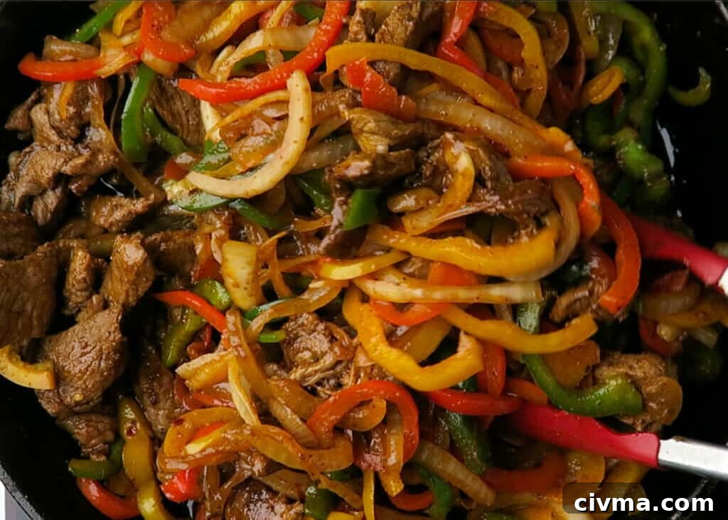 Cooked steak strips added back to peppers and onions