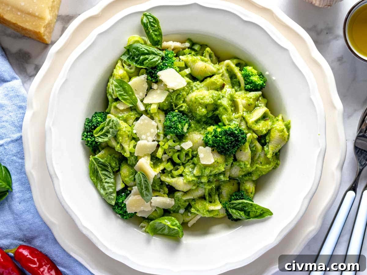 plated broccoli pasta with a garnishing of basil leaves and shaved parmesan