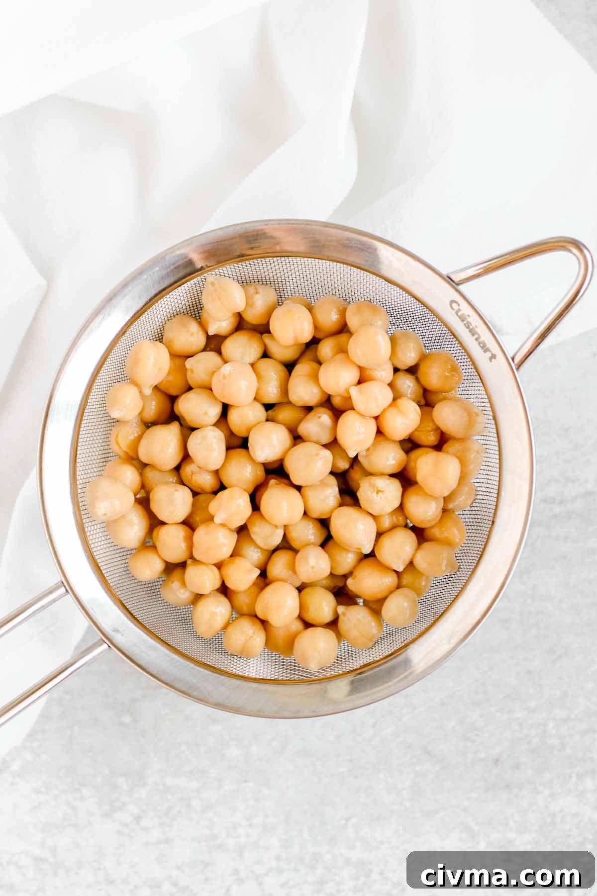 Drained chickpeas in a stainless steel colander.