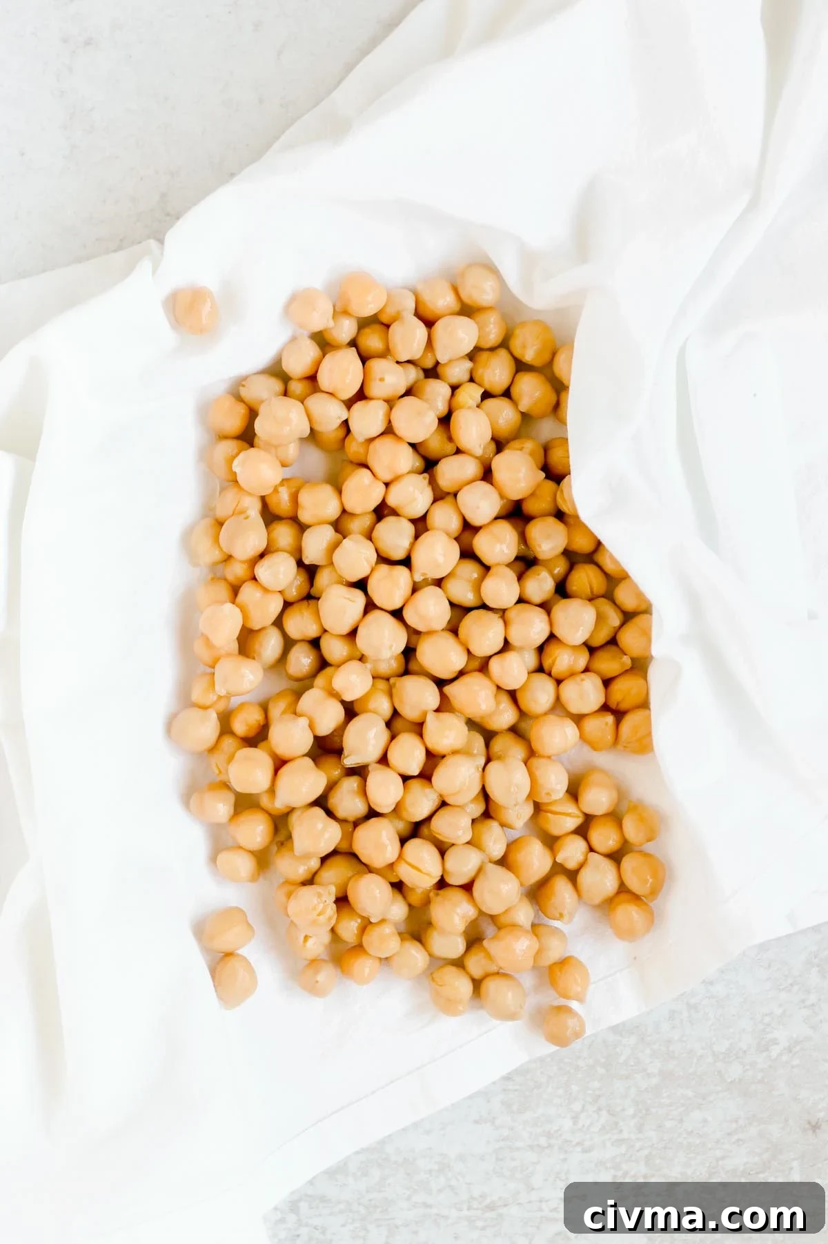 Chickpeas drying in a white flour sack towel.