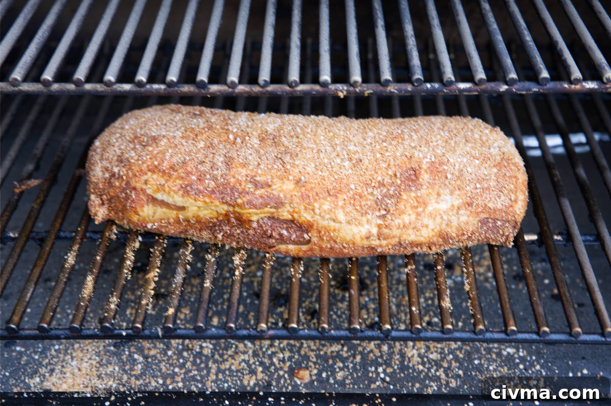 Pork Loin Smoking Time Per Pound and Temperature 3 Pork loin with dry rub on grill grates of smoker.