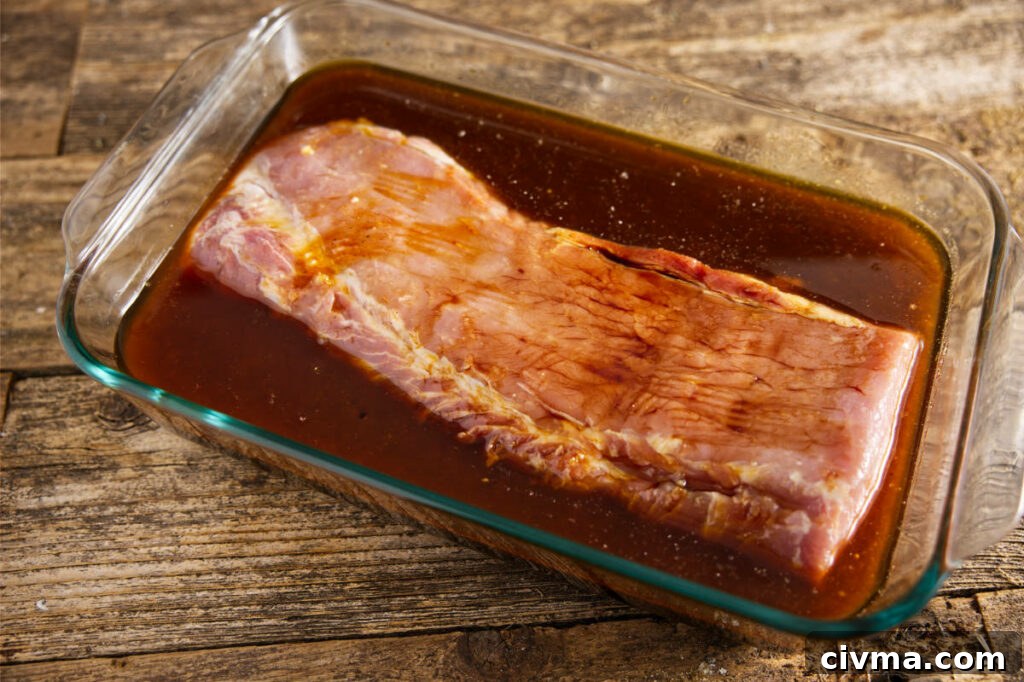 Pork Loin Smoking Time Per Pound and Temperature 5 Pork loin soaking in marinade in large Pyrex.