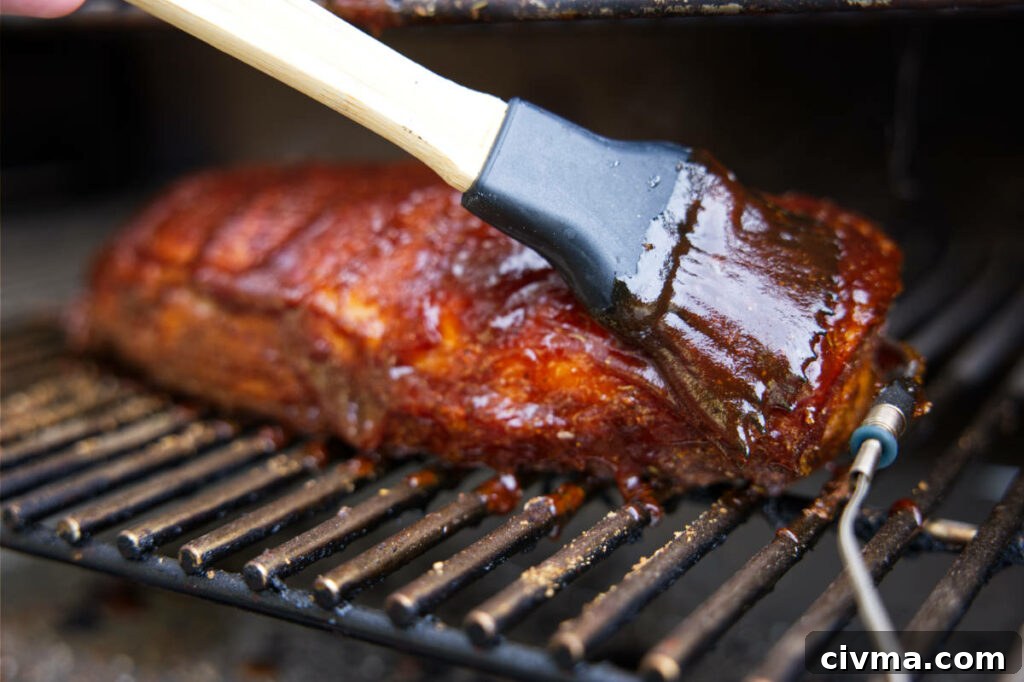 Pork Loin Smoking Time Per Pound and Temperature 7 Brushing BBQ sauce on smoked pork loin.