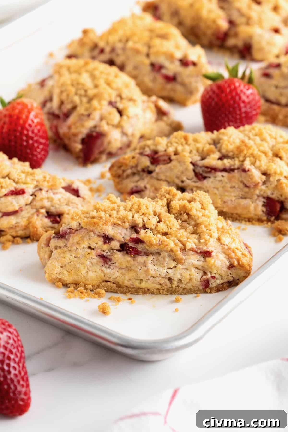 Unbaked strawberry streusel scones on a parchment-lined baking sheet.