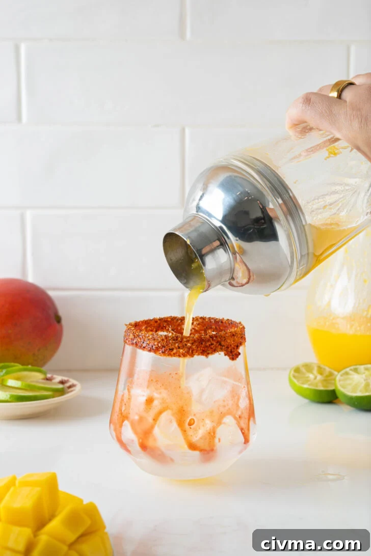 A mango margarita pouring into a glass.