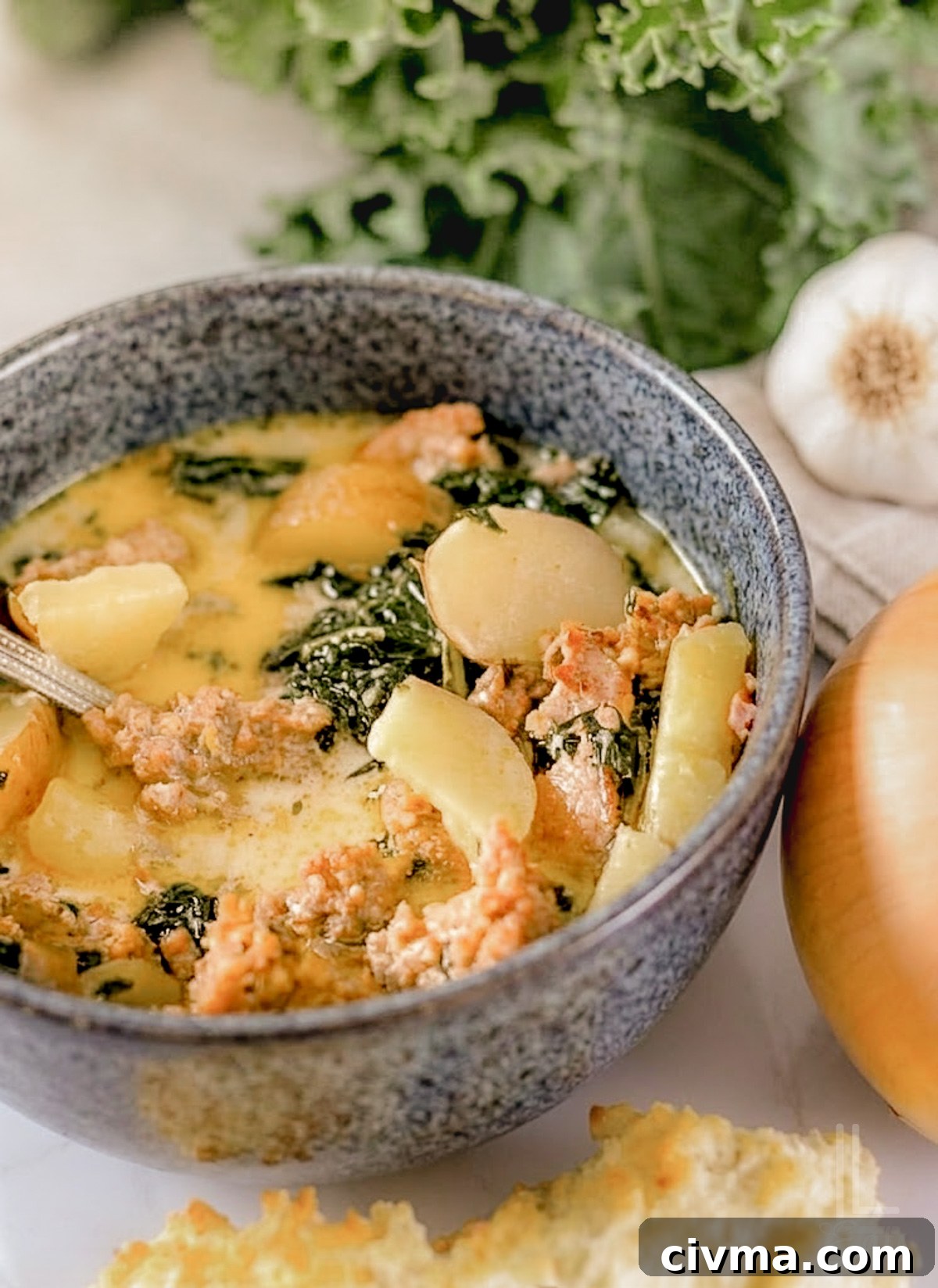 A bowl of creamy Instant Pot Zuppa Toscana with kale, sausage, and potatoes.